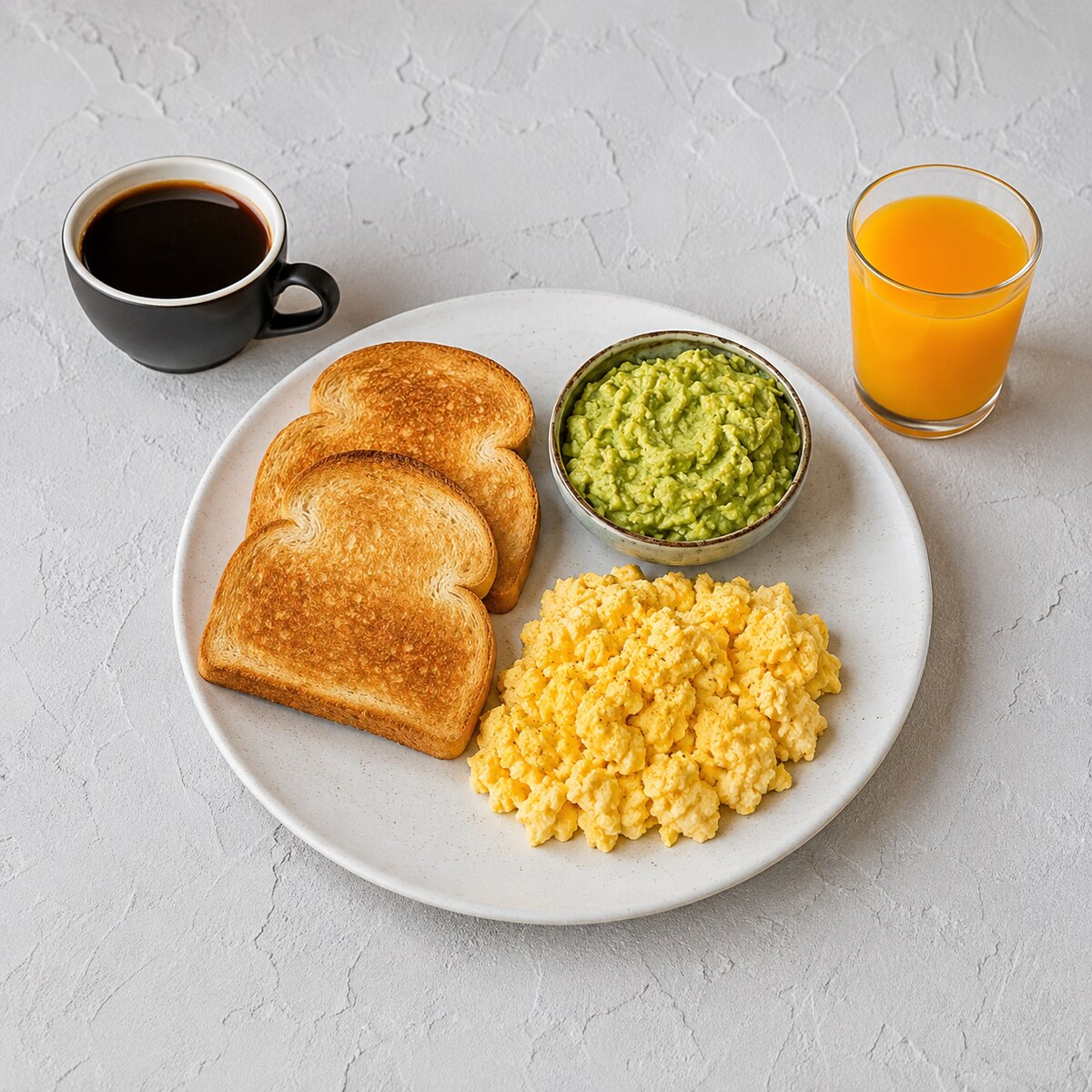 Huevos revueltos, aguacate, pan, café y zumo